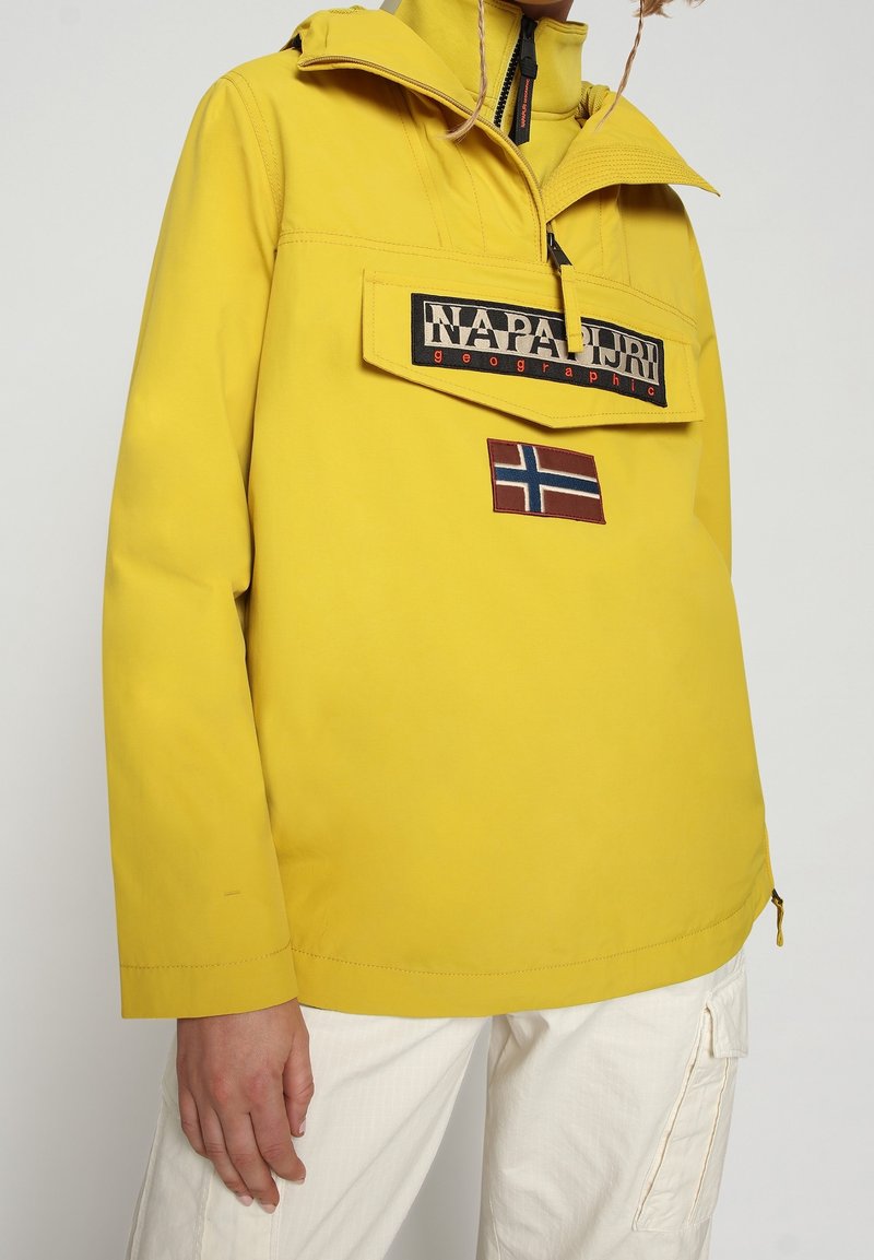 Geel waterdicht anorak met verstelbare kraag, logo patch aan de voorkant en een detail van de Noorse vlag. Heeft een comfortabele pasvorm en een kangoeroezak.