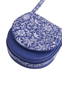 Okrugla plava crossbody torba s bijelim cvjetnim i ptičjim uzorcima na preklopu i remenu, tijelo od teksturirane kože i uredno šivanje.