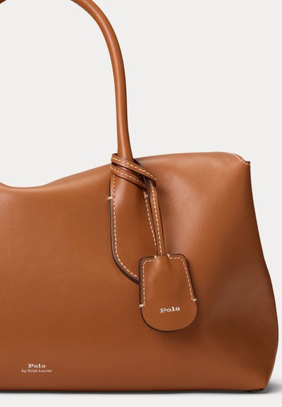 Braune Lederhandtasche mit abgerundeten Kanten, einem einzelnen Griff und einem angenähten Anhänger mit dem eingeprägten Wort Polo.
