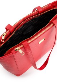Rood leren handtas met textuur, gouden hardware, dubbele ritsen en een binnenvoering van stof met een herhalend logopatroon.