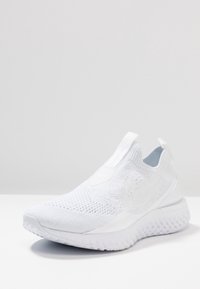 Weißer Sportschuh mit einem Obermaterial aus Strickgewebe, Schlupf-Design und strukturierter Sohle. Verfügt über ein minimalistisches Logo und nahtlose Konstruktion.