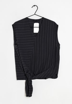 Top sans manches noir avec un décolleté en V, présentant des rayures blanches, un détail noué à l'ourlet et une texture de tissu doux et léger.