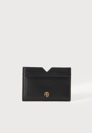 Porte-cartes en cuir noir avec des bords cousus, deux fentes horizontales pour cartes, une encoche en V sur le dessus et un petit emblème doré.
