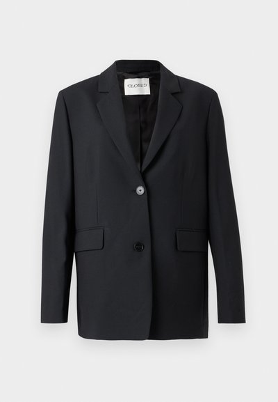 Μαύρο σακάκι με ένα κουμπί κλεισίματος, πέτο με σχισμή, δύο μπροστινές τσέπες και λεία υφή. Η ετικέτα γράφει "CLOSED".