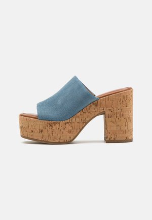 Sandal in denim blu con suola in sughero e tacco spesso, caratterizzato da una ampia fascia anteriore e una soletta liscia marrone.