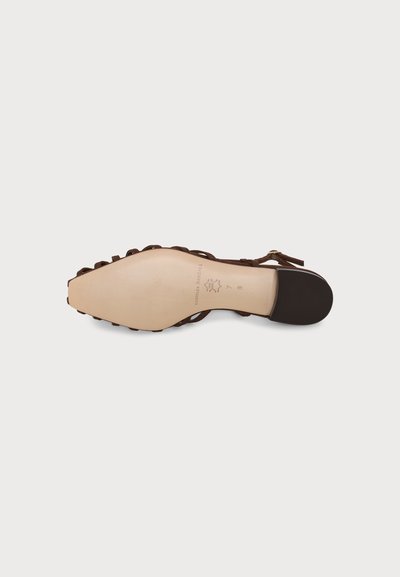 Une chaussure plate marron à brides montrée par la semelle, dotée d'une semelle en cuir et d'un petit talon noir avec des indications de taille et de marque.