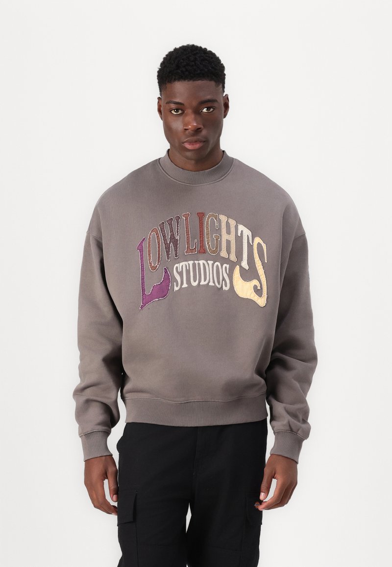 Grijze sweatshirt met "LOWLIGHTS STUDIOS" geborduurd in meerkleurige tekst. Geribbelde ronde hals en manchetten, met een relaxte pasvorm.