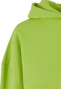 Felpa verde in cotone con cappuccio, caratterizzata da una texture morbida e una vestibilità rilassata. Il tessuto ha un motivo semplice con dettagli di cucitura visibili.