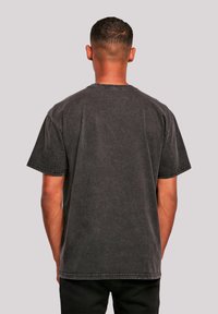 Dark gray short-sleeve t-shirt with a relaxed fit, visible stitching, and a plain texture. No logos or patterns, showcasing a simple design.
