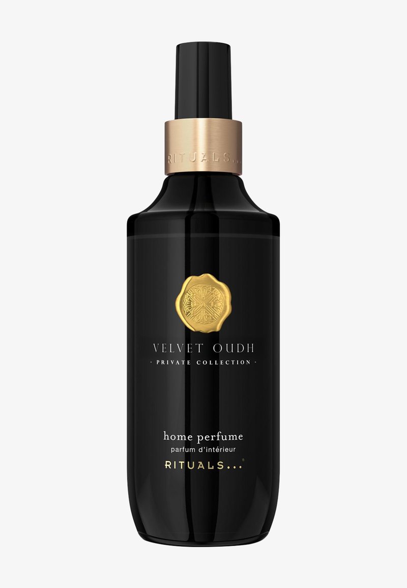 Zwarte glazen fles met een gouden accenten dop, met een gouden embleem en witte tekst. Bevat home fragrance 'Velvet Oudh' van Rituals.