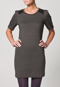 Šedé herringbone šaty s krátkými rukávy, černými akcenty na ramene, kulatým výstřihem a fitted siluetou, sahajícími do poloviny stehna.