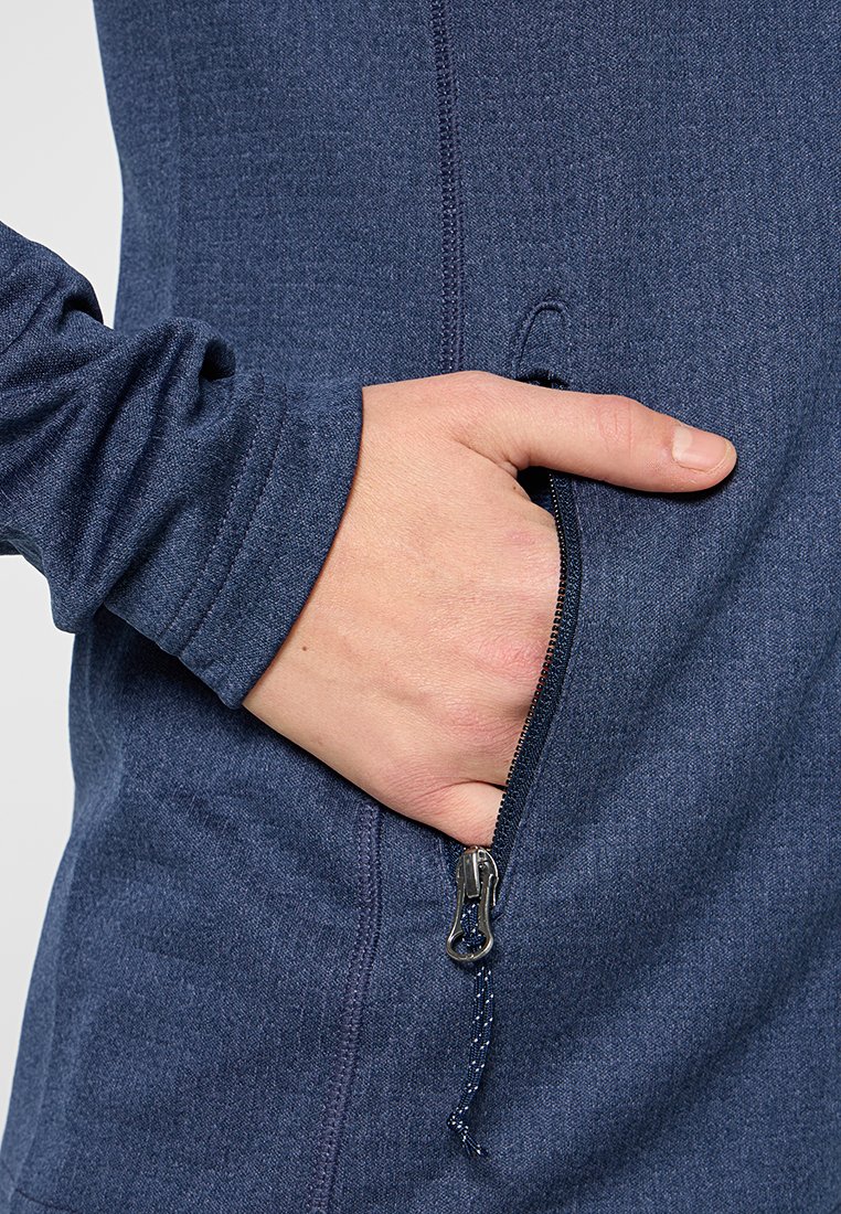 Marineblauwe fleecejack met een ritszak en textuurstof. Inclusief een verstelbare manchette met een slim fit design. Ritskunstof is metallic.