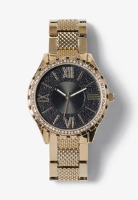 Montre dorée avec un cadran noir texturé, des chiffres romains et une lunette ornée de cristaux. Elle possède un bracelet en maille et un boîtier rond.