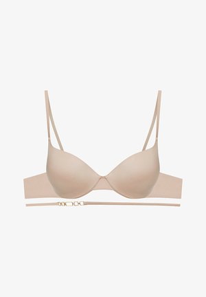 Beżowy biustonosz push-up z gładkimi miseczkami, regulowanymi cienkimi ramiączkami i szeroką, bezszwową taśmą z detalem z claspu w złotym odcieniu.