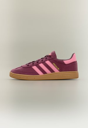 Μπορντό αθλητικό παπούτσι Adidas με ροζ ρίγες και ταμπελάκι στη φτέρνα, καουτσούκ σόλα και χρυσό λογότυπο "Spezial" στο πλάι.