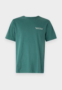 Camiseta de algodón verde de manga corta, con un cuello redondo y un pequeño texto en blanco que dice "Hotel de Palermo" en la parte frontal.