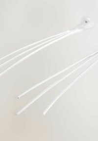 Klare plastikøretelefonledninger med tre tynde tråde, der har en tekstureret overflade og en lille metalforbindelse.