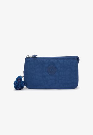 Trousse zippée en tissu bleu marine avec un logo circulaire et un petit porte-clés singe en peluche accroché sur le côté gauche.