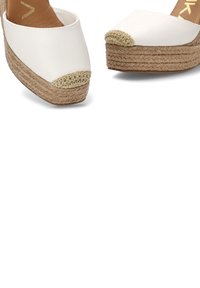 Zapatos plataforma blancos con cuñas, suelas de yute trenzado y detalles de crochet beige en las puntas.