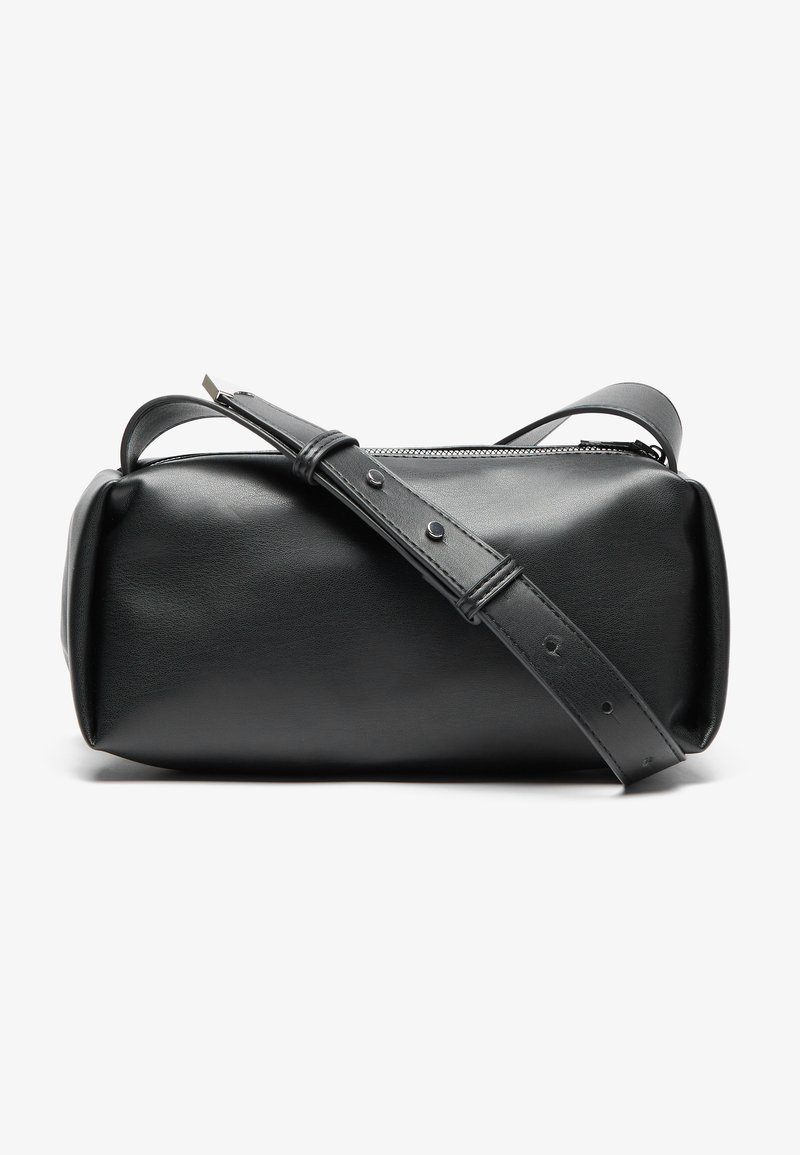 Bolso cruzado de cuero negro con forma cilíndrica, cierre de cremallera y correa ajustable. Textura suave con detalles de diseño minimalistas.