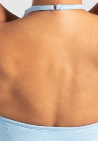 Top azzurro chiaro con spalline incrociate sul retro, caratterizzato da una texture di tessuto liscia, con una sottile tracolla e un delicato dettaglio di chiusura al collo.