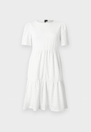 Robe blanche longueur genou avec manches courtes bouffantes, encolure ronde, jupe à volants et un subtil motif œillet chevron.