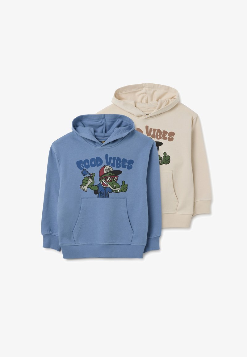 Dos sudaderas con capucha: una en azul claro con un diseño gráfico que incluye "Buen rollo" y un caimán caricaturesco verde; la otra en color crema con un texto similar.