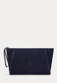 Τσάντα Polo Ralph Lauren σε ναυτικό μπλε με φερμουάρ, ανάγλυφο λογότυπο και λουράκι καρπού στην αριστερή πλευρά.