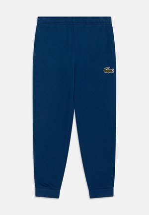 Marineblaue Jogginghose mit elastischem Bund und Bündchen am Knöchel, mit kleinem grün-rotem Krokodil-Logo am rechten Oberschenkel.