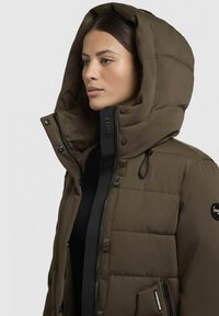 Bruine gewatteerde jas met een grote capuchon, rits- en drukknoopsluiting, verstelbare toggles en een opvallende logopatch op de mouw.