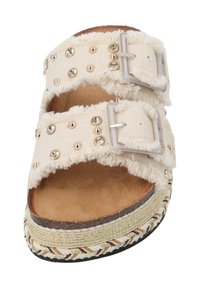 Helle beige Sandalen mit zwei verstellbaren Riemen, verziert mit metallischen Nieten und einer fransigen Stofftextur. Dicke geflochtene Sohle mit goldenen Akzenten.