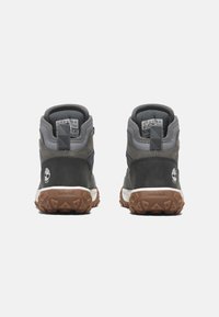Dark gray mid-top hiking shoes with a textured suede and synthetic upper, white midsole, and brown rubber outsole featuring traction lugs.