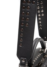 Juodas odinis delninukas su kuprinėmis, lygia tekstūra ir apvaliais rankenėlėmis. Išskirtiniai bruožai - metalinės detalės ir elegantiškas dizainas.