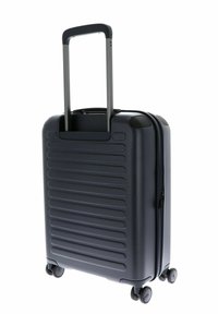 Valise de cabine rigide en marine foncé, dotée de rainures horizontales, d'une poignée télescopique et de quatre roues à roulement fluide.