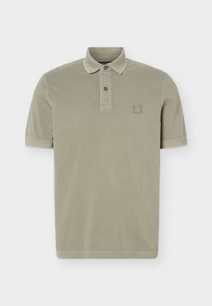 Beige lyhythihainen poolopaita, jossa on kaksi nappia ja pieni neliönmuotoinen logo vasemmassa rinnassa.