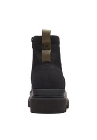 Botas negras con un upper texturizado, material en contraste en el talón, una lengüeta en bucle y una suela negra gruesa.