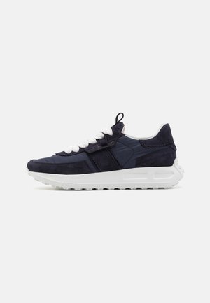 Lavtop navy sneakers med hvide tykke snørebånd, ruskind og stofpaneler, samt en tekstureret hvid gummisål.