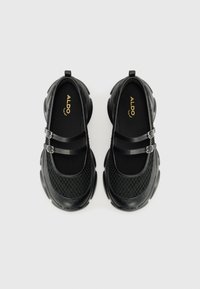 Scarpe Mary Jane nere con tomaia in rete testurizzata, design a doppia cinghia con fibbie e suole in gomma spessa con forma arrotondata.