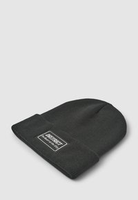 Berretto in maglia nera con risvolto e una patch rettangolare bianca con testo nero che dice "DISTRICT - Il cuore della città."
