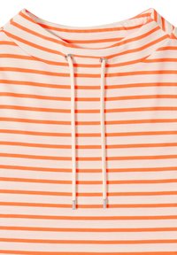 Gros plan sur l'encolure d'un sweat à capuche rayé orange et blanc avec deux cordons blancs se terminant par des embouts argentés.