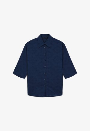 Camicia a maniche corte con bottoni in tessuto blu scuro con un motivo sottile, dotata di colletto classico e cinque bottoni coordinati lungo la parte anteriore.