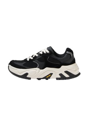 Czarne sneakersy z białymi sznurowadłami, wykonane z materiałów syntetycznych. Posiadają fakturowane czarne panele, masywną białą podeszwę środkową oraz czarną gumową podeszwę.