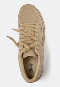 Zapatilla beige con parte superior sintética lisa, puntera redonda, cuello acolchado e interior texturizado. Cuenta con cordones planos y una marca minimalista.