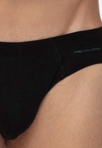 Schwarze Baumwollunterhosen mit eng anliegender Passform, ausgestattet mit einem flachen Bund und subtilen Logodetails in Grau. Glatte Textur und keine sichtbaren Muster.