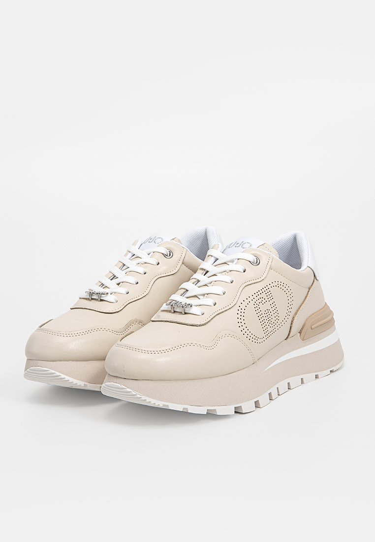 Zapatillas beige de cuero con textura suave, puntera redonda, detalles laterales perforados, cordones blancos y suela gruesa.