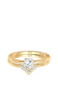 Goldfarbener Ring mit rundem zentralen Stein und V-förmigem Akzent. Verfügt über glatte Bänder und mehrere kleine Steine entlang des V.