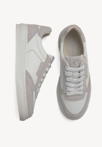 Adidași albi și gri cu un superior din piele netedă, cu accente de velur, talpă texturată și șireturi plate albe.