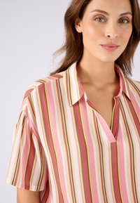 Gestreepte blouse in roze, crème en groene tinten, met korte mouwen, een kraag en een ontspannen pasvorm. Gelaagd materiaal met een lichte glans.