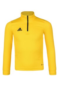 Maglietta sportiva gialla a maniche lunghe con colletto alto, chiusura a metà zip davanti e logo Adidas nero sul lato sinistro del petto. Tessuto liscio, design aderente.