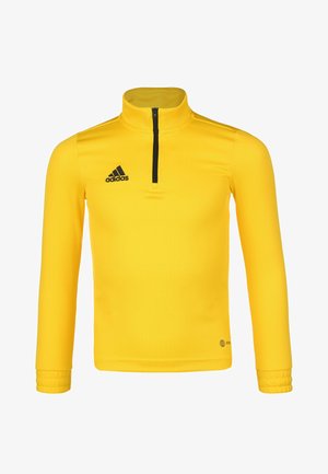Camiseta atlética amarilla de manga larga con cuello alto, cierre de media cremallera en el frente y logo negro de Adidas en el lado izquierdo del pecho. Tela suave, diseño ajustado.
